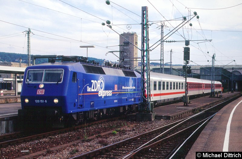Bild: 120 151 bei der Einfahrt in Stuttgart Hbf., wo sie gerade ihren Zug reinschiebt. 
Am Ende des Zuges steht ein Rangierer und beobachtet die Strecke.