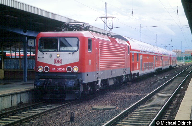 Bild: Sie ist die erste Serienlok der damaligen BR 112.0 gewesen. Ihren orientroten Lack mit den hochgezogenen weißen Streifen neben der Fenster hat sie auch nicht mehr. 
Hier steht die 114 002 in Flughafen Berlin-Schönefeld.