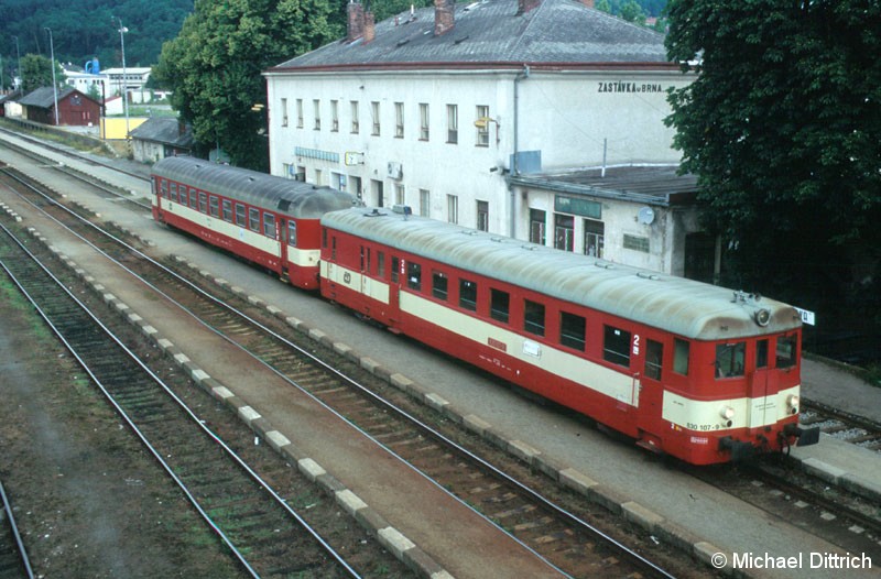 Bild: Blick von einer Brücke auf den 830 und das Bahnhofsgebäude von Zastavka.